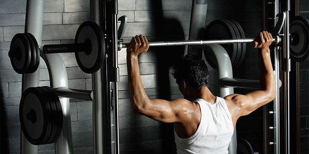 A Man Doing Exercise with Smith Machine Bar 