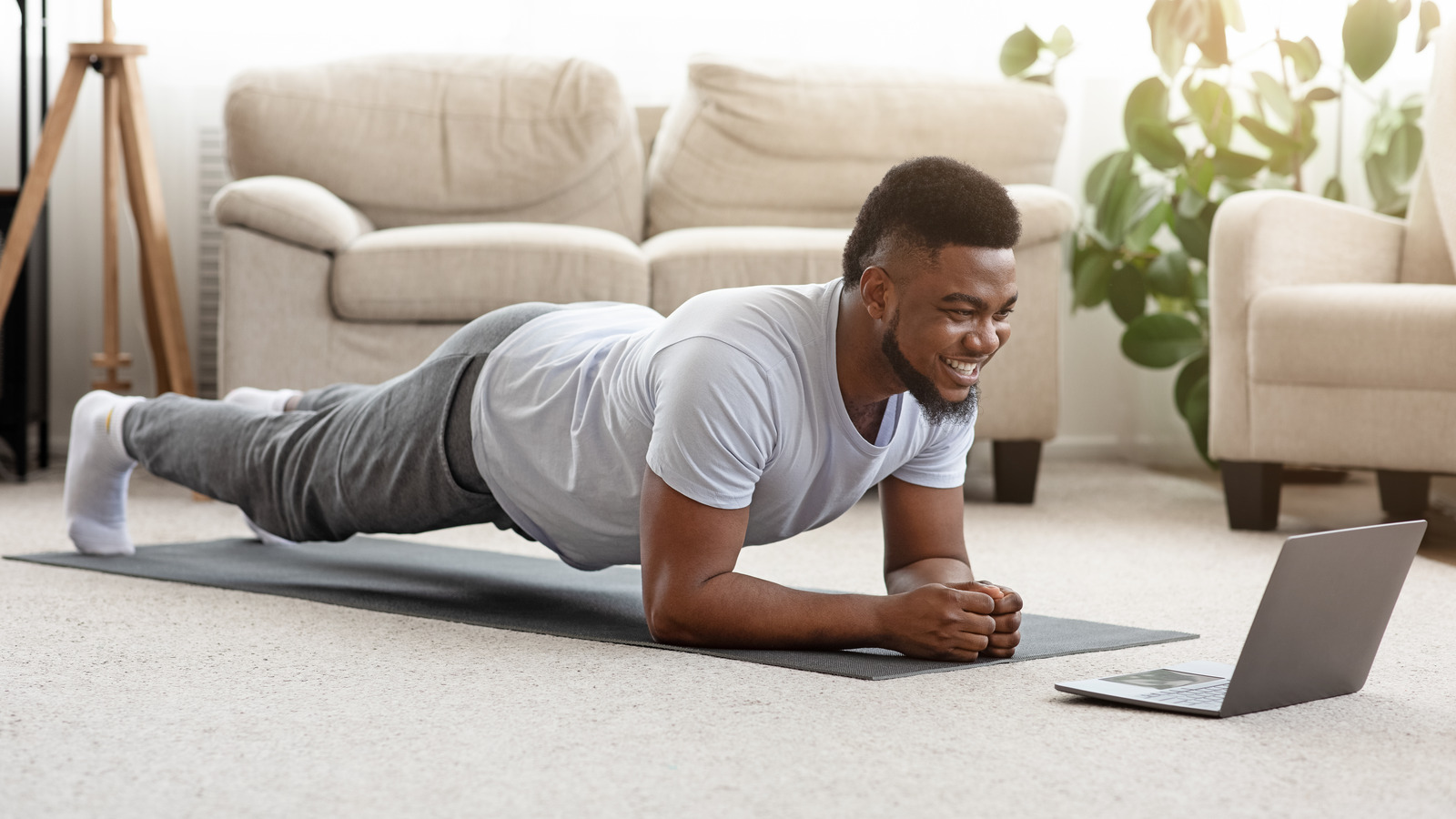 A man doing planks with right and left leg extended and not doing side lying hip abduction for body weight as a workout at home with 10 reps and an elevated push